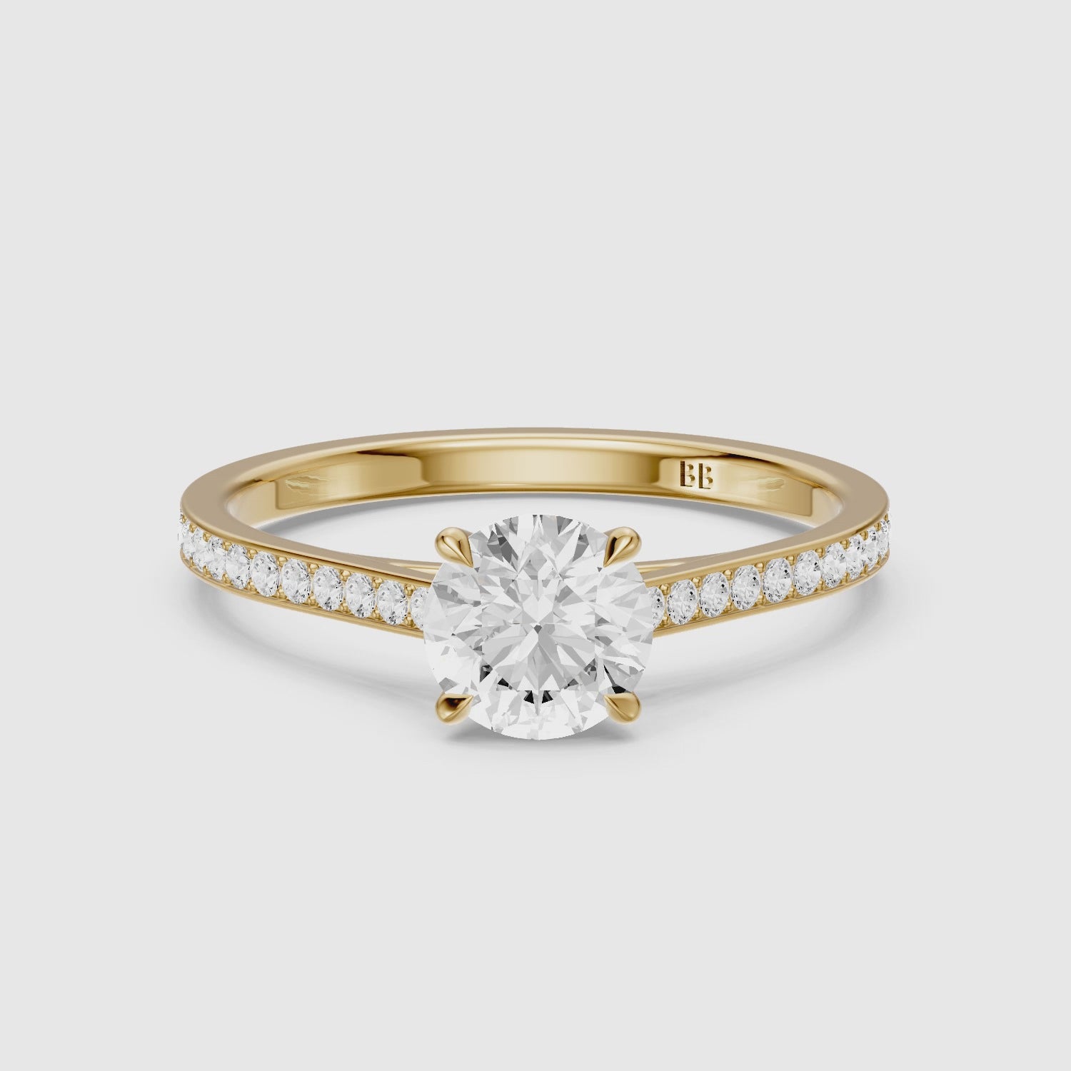 Load video: Callie 4 Prong Round Cut Side Stone Channel Set Moissanite Diamond Ring