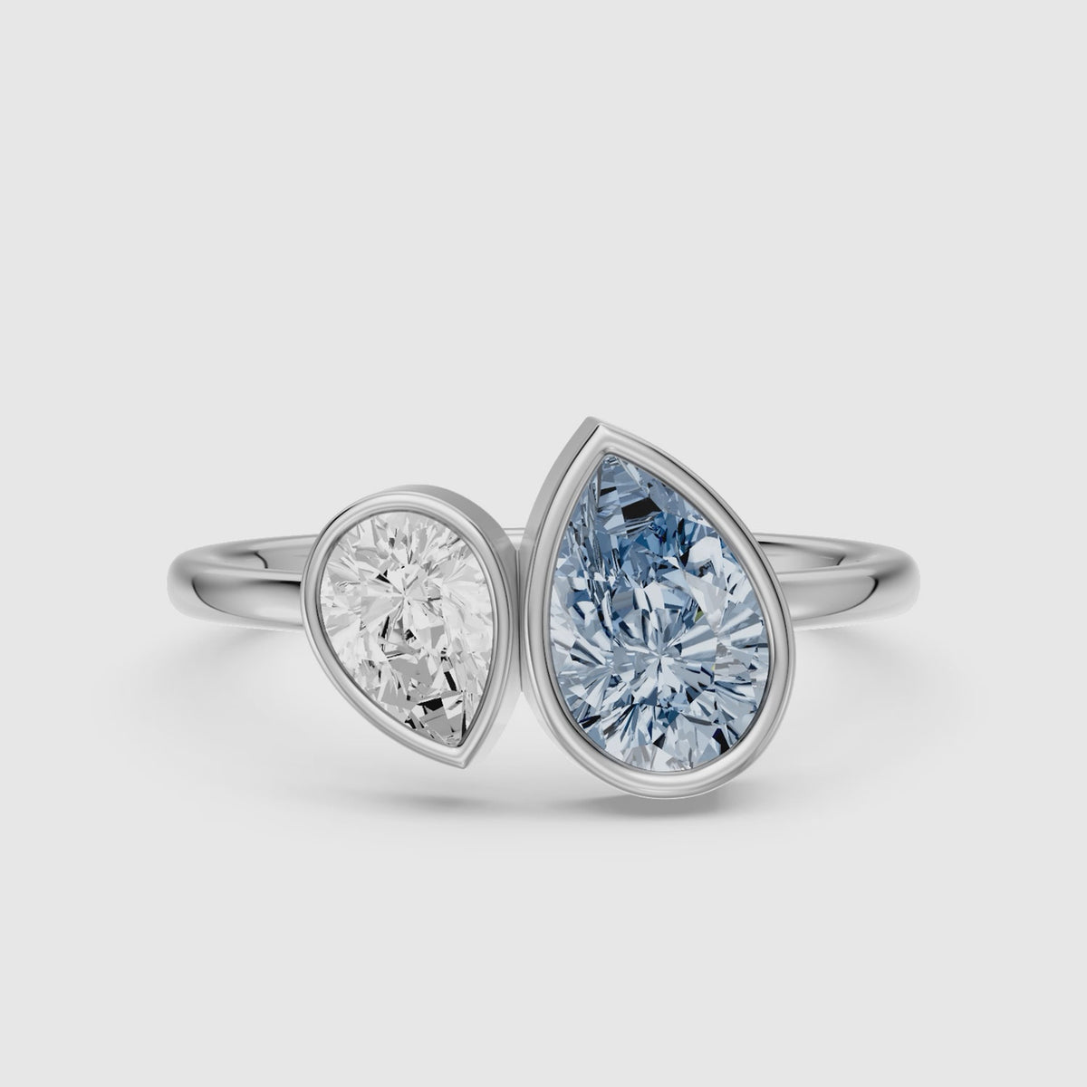 Load video: Nicolina Blue and White Pear Cut Colored Lab Grown Diamond Toi et Moi Bezel Ring