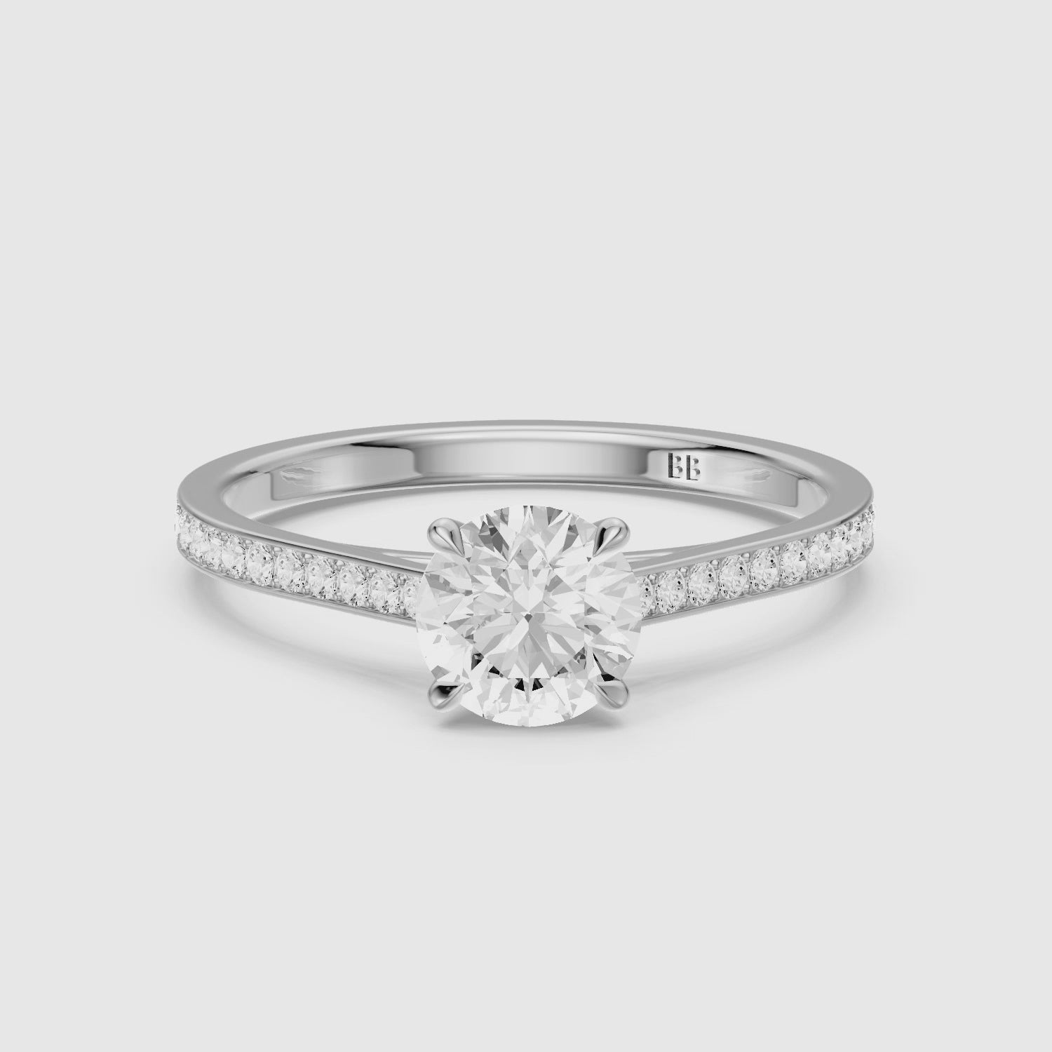 Load video: Callie 4 Prong Round Cut Side Stone Channel Set Moissanite Diamond Ring