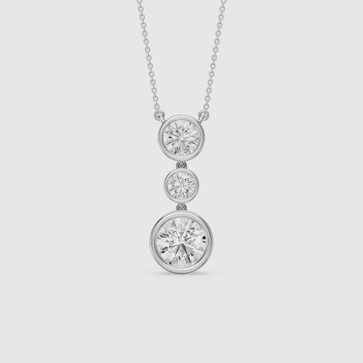 Load video: Esmeralda Three Stone Round Bezel Lab Grown Diamond Pendant