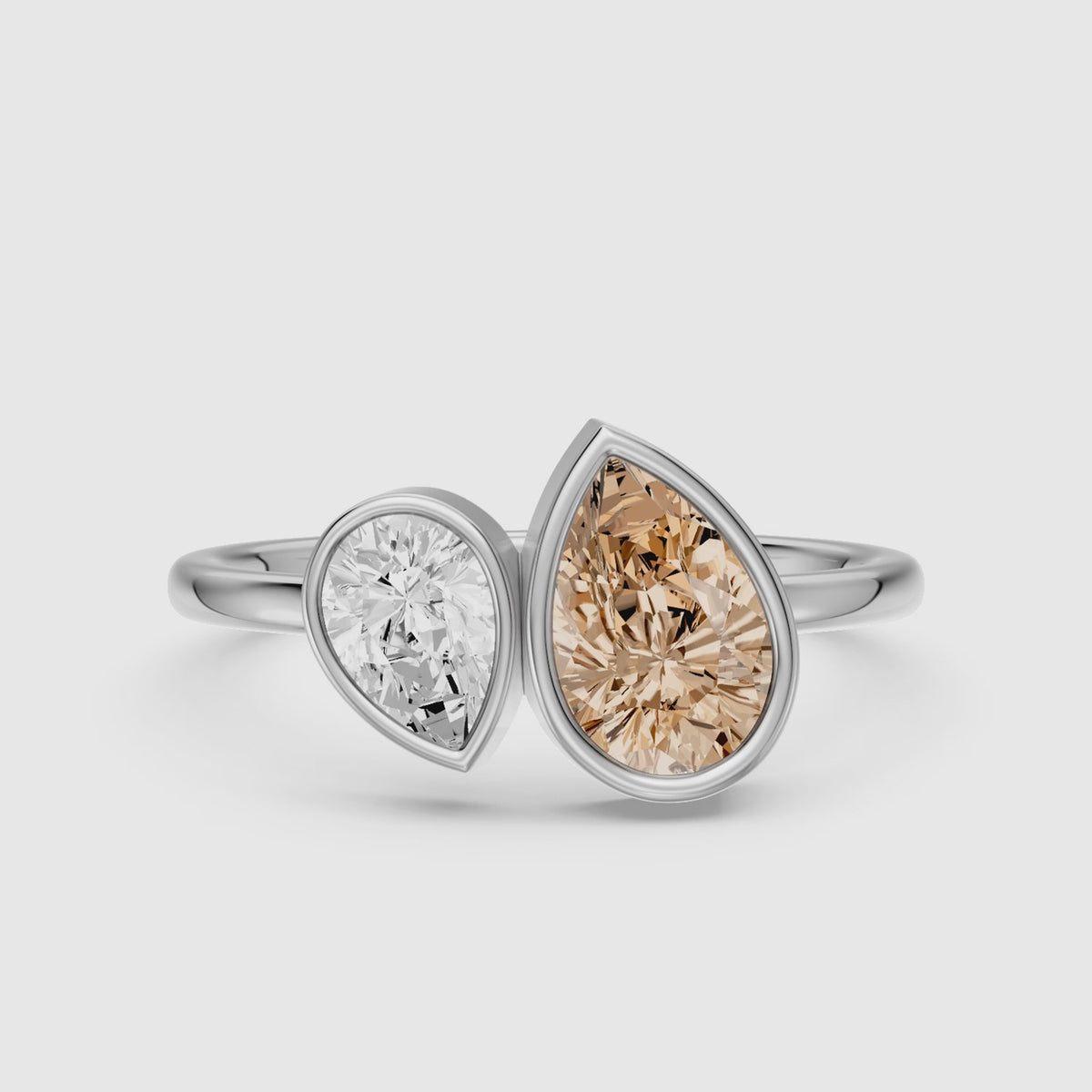 Load video: Ottilie Champagne and White Pear Cut Colored Lab Grown Diamond Toi et Moi Bezel Ring